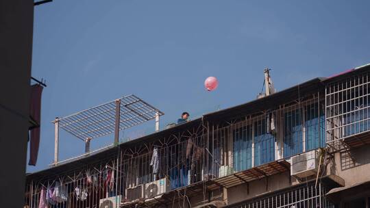 长沙居民区楼顶拿气球的小孩