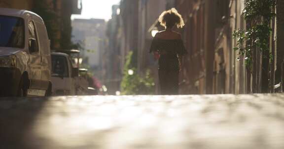 走在城市阳光明媚的街道上的女人