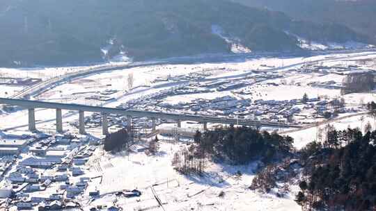 中国黑龙江高铁列车冬季行驶在雪乡村落