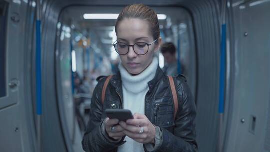 女孩在地铁上玩手机视频素材模板下载