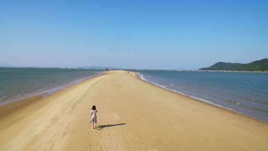 年轻女孩在漳州东山岛鱼骨沙洲漫步碧海蓝天