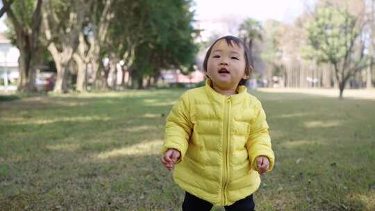 初学走路的可爱小女孩在公园里快乐玩耍