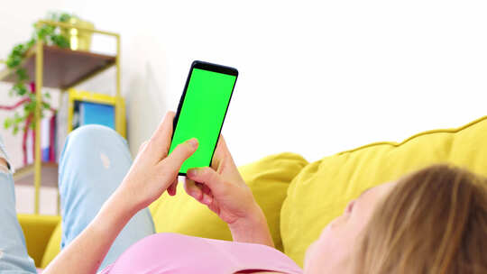 粉色上衣金发女郎手中拿着带绿屏色度键的手机视频素材模板下载