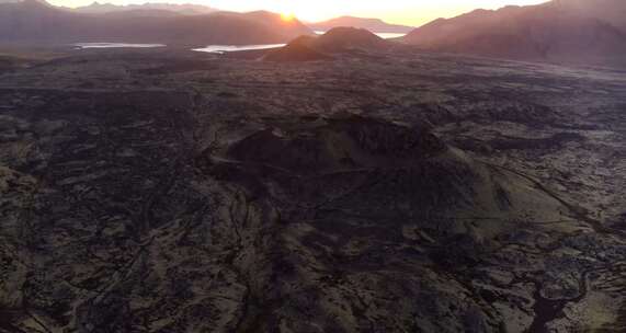 日落时贫瘠的景色中湖边的火山山脉视频