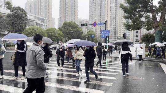 下雨天城市斑马线上穿行的人流