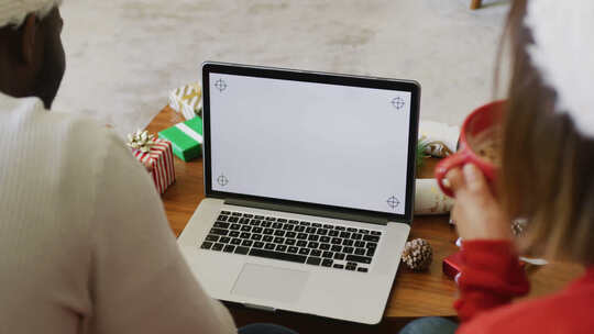 快乐的多样化夫妇在家进行圣诞笔记本电脑视频通话的视频，在屏幕上复制空间