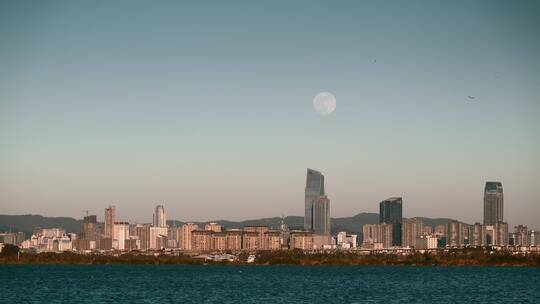 滇池畔远眺昆明城市升起月亮