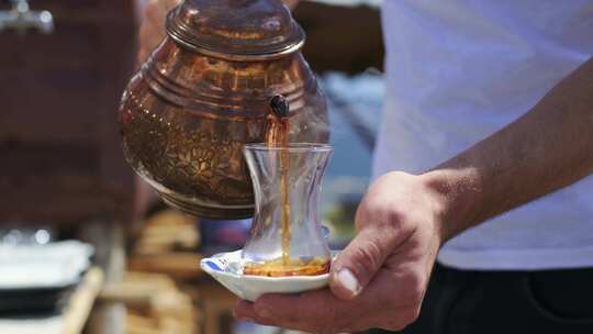 传统土耳其茶被倒入传统土耳其茶杯。4K慢