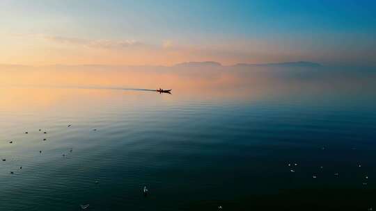 昆明滇池夕阳水面一只捕捞船远景