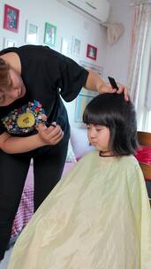 为女儿剪发的中国母亲