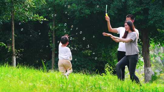 小男孩开心在户外公园玩耍幸福家庭亲子时光