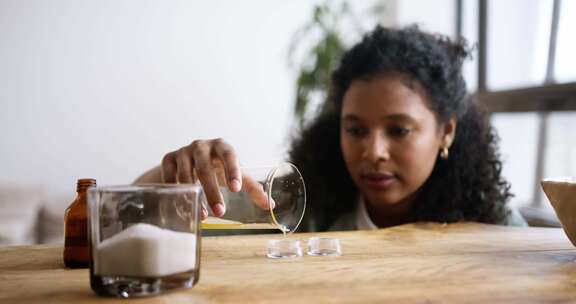 一个女人把蜂蜡倒入小容器