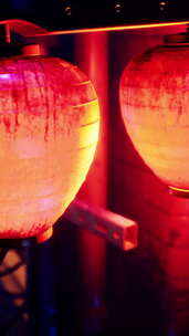 三盏红黄相间的灯笼挂在杆子上