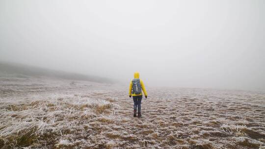 雾天在冻土上行走的人