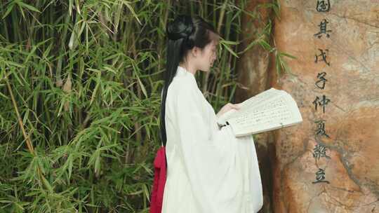 古风汉服美女在竹子旁看书