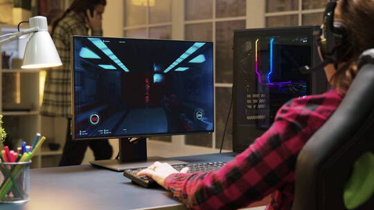 戴着耳机的女人在玩电脑游戏视频素材模板下载