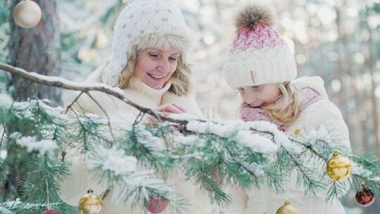 母女摸树叶上的白雪