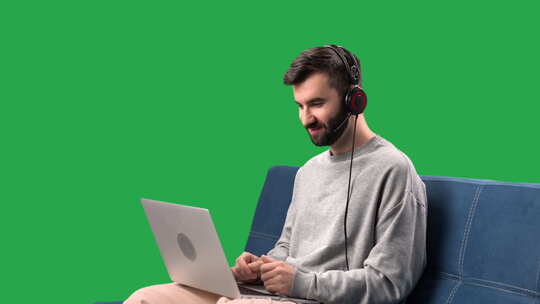 男人说话在线视频通话使用笔记本电脑在沙发上远程会面隔离绿屏色度键
