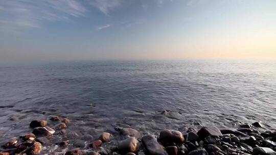 日落时到达岩石海岸的海浪
