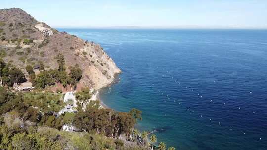 Flyby Descando Beach，Catalina岛，加利福尼亚州。展示部分海滩和岩石山坡视频素材模板下载