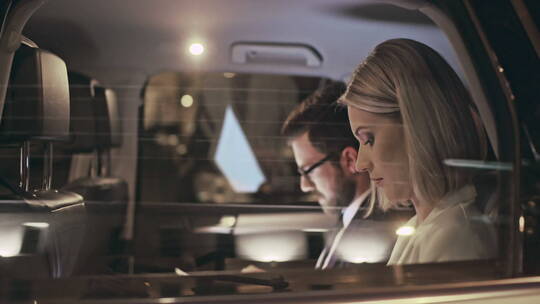 汽车里一对穿着智能衣服的夫妇阅读文件视频素材模板下载