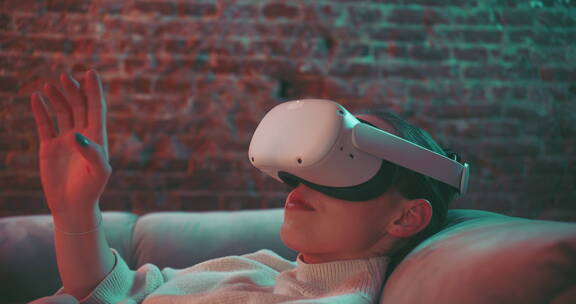 年轻女子躺在沙发上体验VR