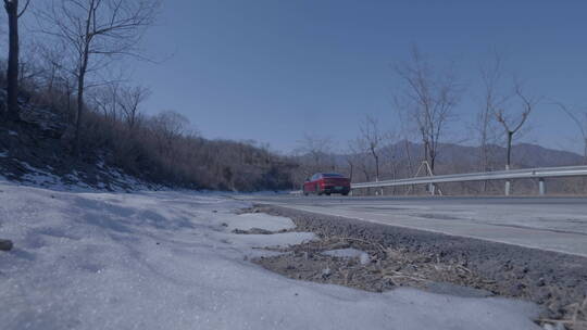 红色新能源电动车山路转完 雪地角度