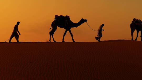 人牵着骆驼在沙漠上行走