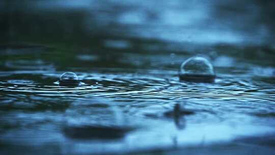 阴沉天气下雨天雨滴落下冒泡特写