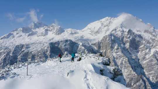 男人和女人在积雪覆盖的山顶上组装他们的装