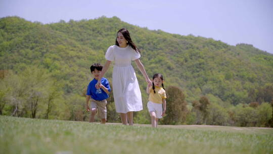 年轻妈妈和孩子们在郊外玩耍