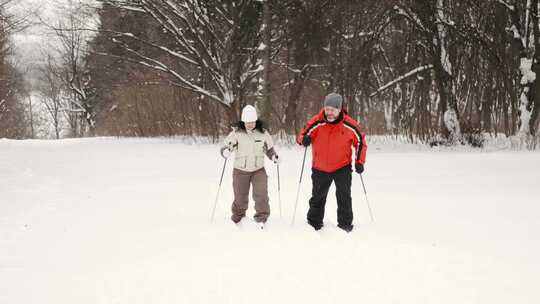 一对穿着滑雪装备在雪地里行走的夫妇