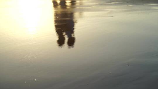 情侣牵手走在海边倒影唯美沙滩光影浪漫散步
