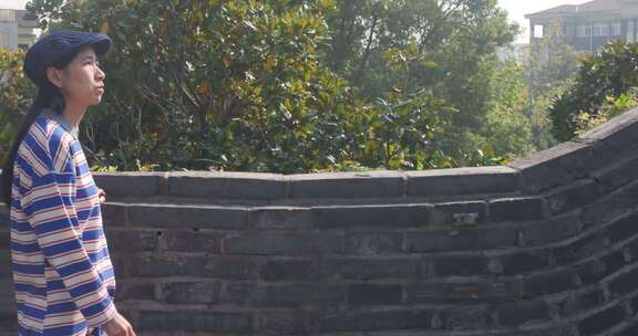 女子行走古城墙眺望远方