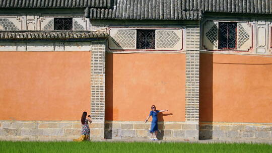 喜洲网红墙前拍照的游客