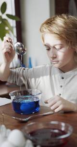男孩在搅拌一碗蓝色液体竖屏