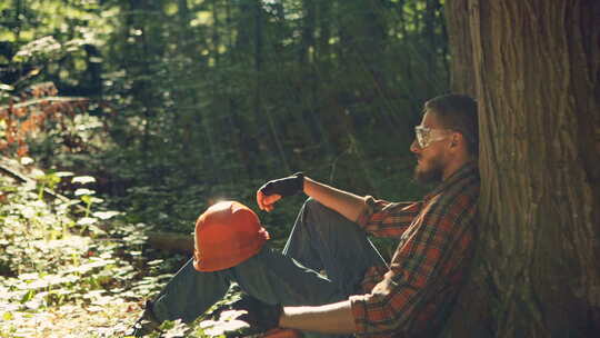 男性伐木工坐在地上休息