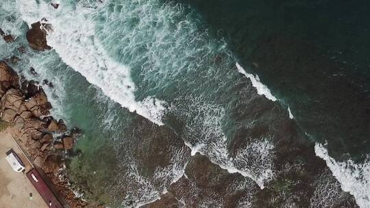 航拍海浪冲向岸边石头