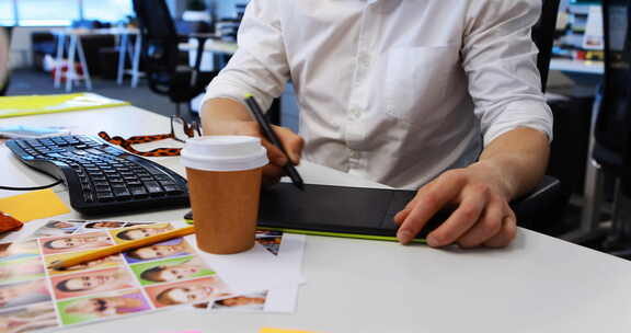 男性平面设计师在办公桌上从事图形平板电脑
