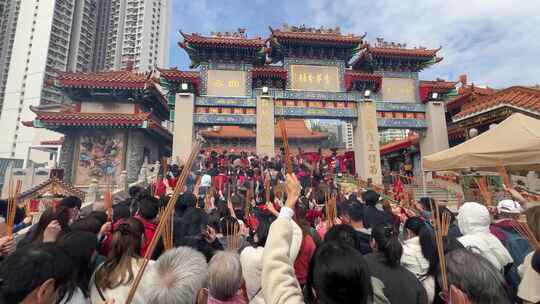 中式建筑前人群聚集上香的场景