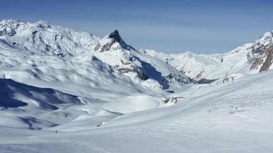无人机穿越被大雪覆盖的山脚