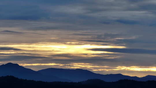 夕阳时的山川大地，一架飞机从天空飞过