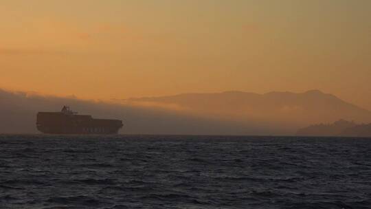 日落时分一艘航行的货船