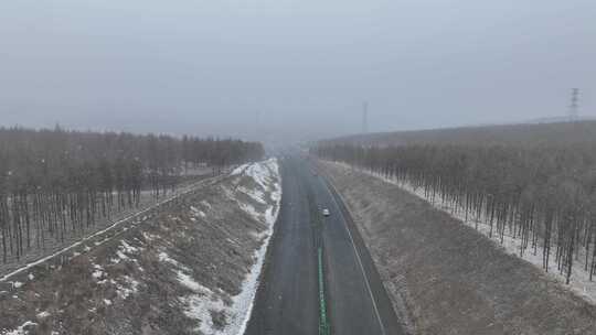 初春风雪大兴安岭林区道路上行驶的汽车