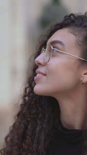 戴着眼镜微笑的摩洛哥女人欣赏城市建筑的美