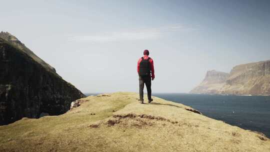 一个人走向海边山上的悬崖