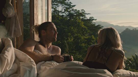 情侣在度假宾馆床上看风景