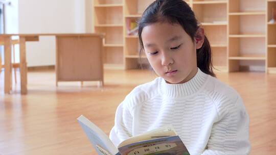 4K升格实拍坐在图书馆书架旁看书的女孩视频素材模板下载