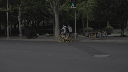 马路上骑共享单车的人