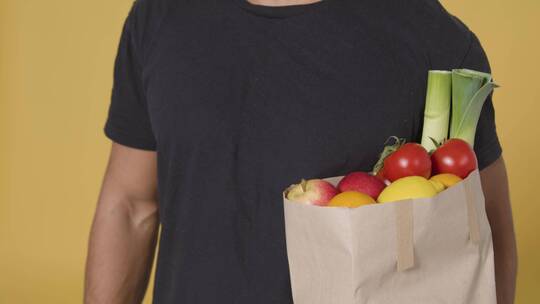 男子拿着一袋水果和蔬菜的特写镜头视频素材模板下载